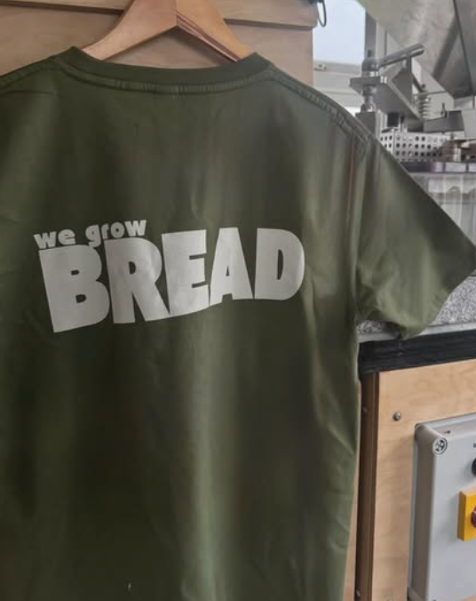 Olive green Plúr t-shirt with we grow BREAD printed on the back